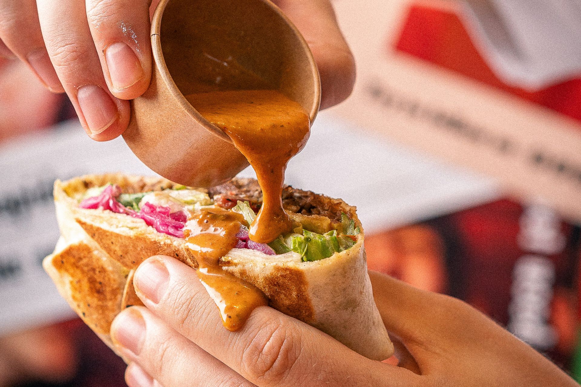 מזיגת רוטב על כריך